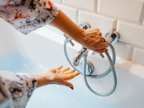Armatur und Wasserlauf an der Badewanne werden geprüft